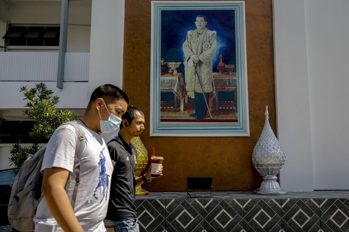 Mensen lopen in Bankok langs een portret van koning  Maha Vajiralongkorn Bodindradebayavarangkun.