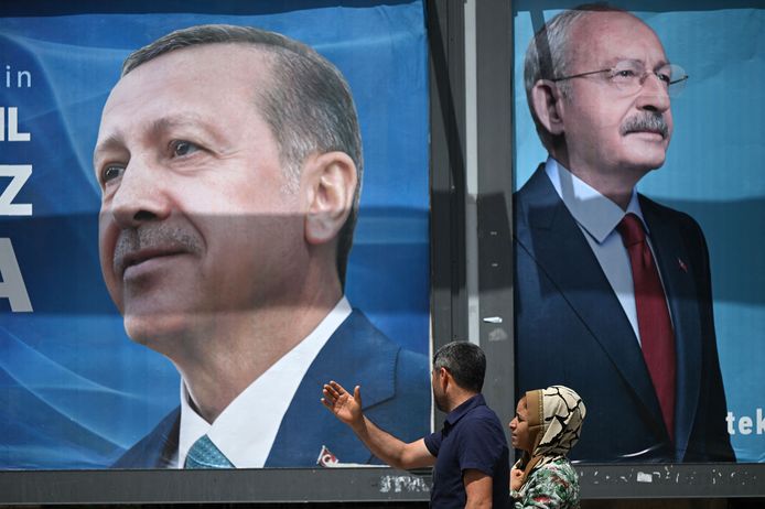 Una coppia passa davanti a cartelloni con un ritratto del presidente turco Recep Tayyip Erdogan (a sinistra) e con un ritratto del leader del Partito popolare repubblicano (CHP) e candidato alla presidenza Kemal Kilicdaroglu (a destra) a Sanliurfa, Turchia sud-orientale, il 28 aprile 2023 (Foto di Ozan Kose/AFP )