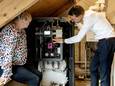 Ter illustratie: een medewerker van Vattenfall staat bij een pilot van de nieuwe hogetemperatuurwarmtepomp in een woning.