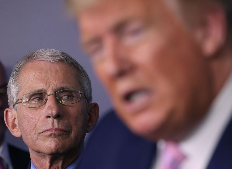 Virusexpert Anthony Fauci luistert naar een toespraak van de Amerikaanse president Donald Trump. Beeld Getty Images