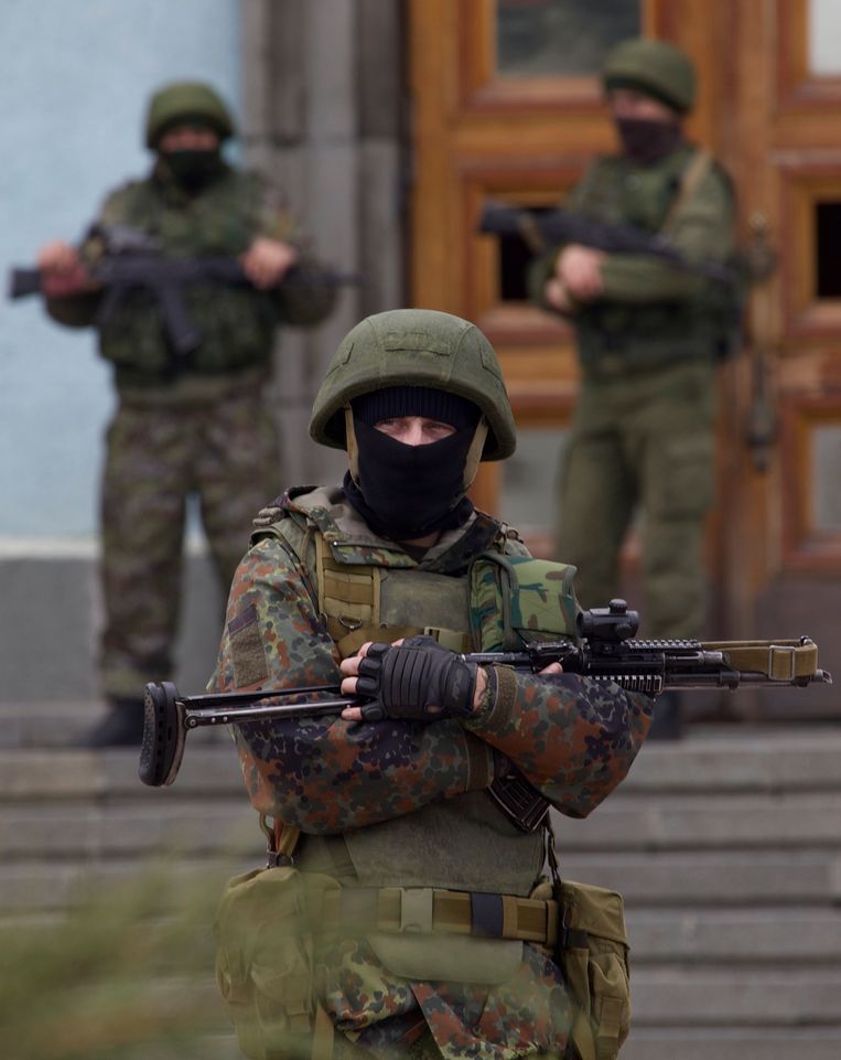 Militairen zonder insigne bewaken het parlementsgebouw van de Krim in Simferopol. Achteraf bleken de ‘groene mannetjes’ speciale eenheden van de Russische strijdkrachten te zijn die de taak hadden de annexatie van het Oekraïense schiereiland voor te bereiden. Beeld AP
