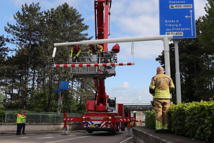 De brandweer hangt de balk weer terug nadat er weer een vrachtwagen tegenaan is gereden.