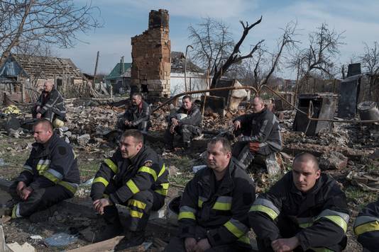 Hulpverleners rusten uit bij het puin van een vernield gebouw in Borodjanka, een voorstad van Kiev. 
