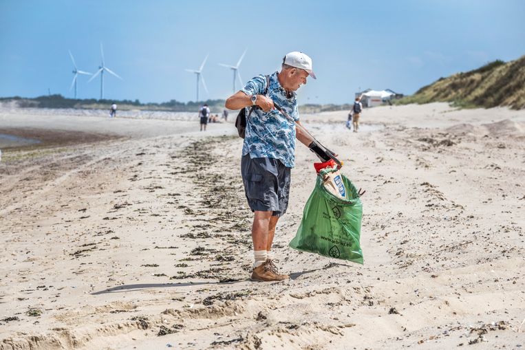 Vrijwilligers maken het strand schoon bij de Zeeuwse plaats Vrouwenpolder. Beeld Raymond Rutting / de Volkskrant