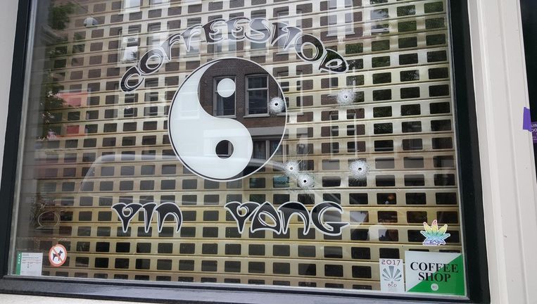 Kogelgaten in het raam van coffeeshop Yin Yang in de Knollendamstraat Beeld Het Parool