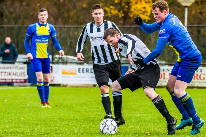 De Tukkers-speler Marco Stege omspeelt tegenstander Sam Holsink van Reutum.