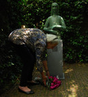 Mariëtte Coppens legt in 2013 bloemen aan de voet van haar beeld van Anne Frank, dat die dag werd geplaatst in de tuin van het Achterhuis in Amsterdam