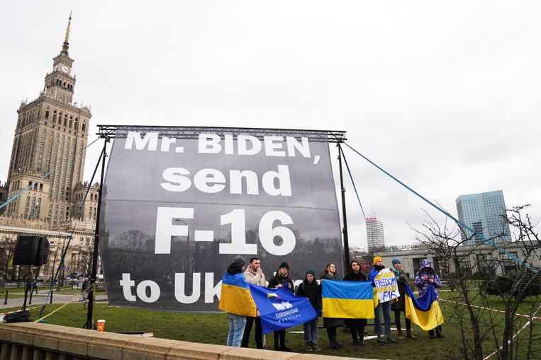 Pro-Oekräiense demonstranten in Polen voor het Marriott-hotel in Warshau, waar de Amerikaanse president Joe Biden verblijft, op 22 februari 2023. Zij roepen de president op om F-16 straaljagers te sturen naar Oekraïne.  Beeld REUTERS