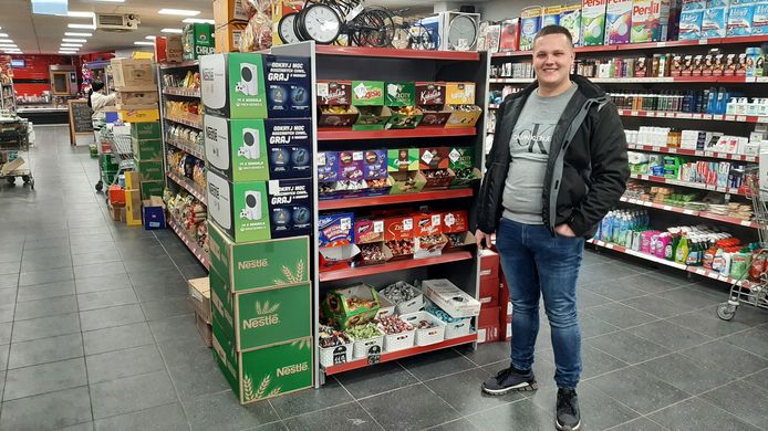 Dariusz Oleksiak, manager van de Polski Sklep Swojska Chata, gaat de klanten samen met zijn personeel in de gaten houden.