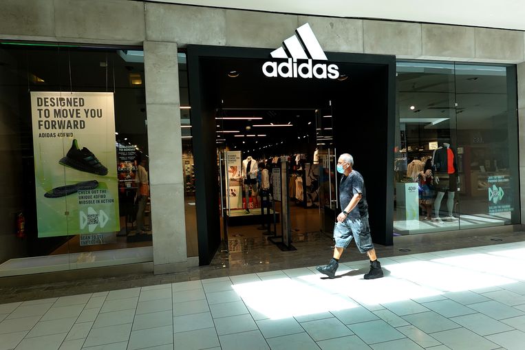 Een man wandelt voorbij een Adidas-winkel in Miami. Beeld Getty Images