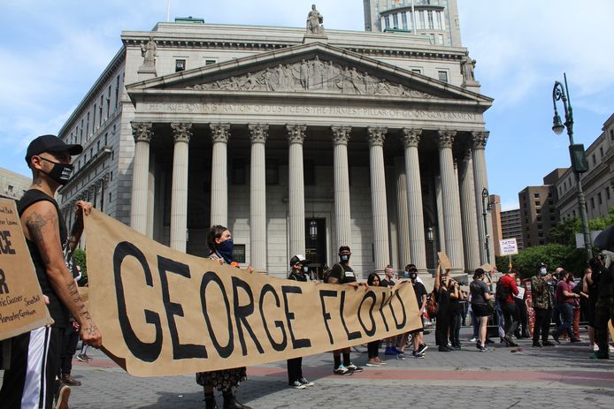 Demonstranten met een spandoek met daarop de naam van George Floyd voor de rechtbank van New York.