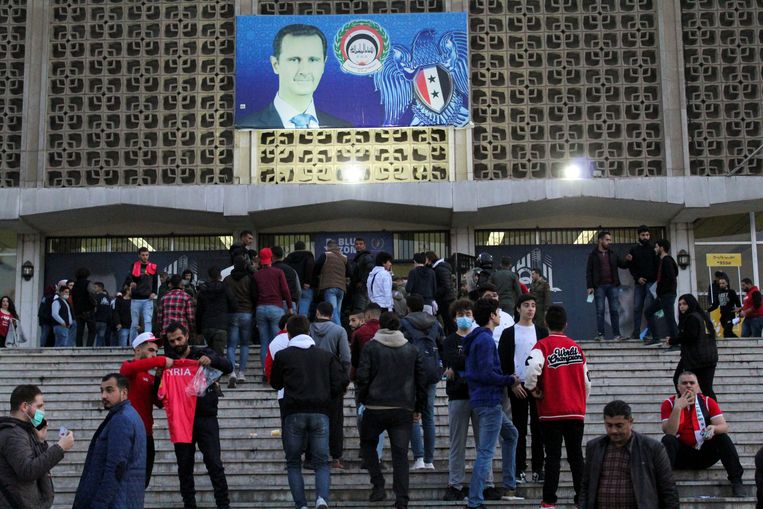 Bezoekers van de basketbalwedstrijd tussen Syrië en Kazachstan verzamelen zich buiten het stadion in Damascus.  Beeld Reuters