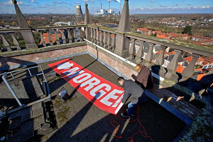 Wethouder Kevin van Oort en Minie van de Weerd van Morgen halen het spandoek van de Geertruidskerk.