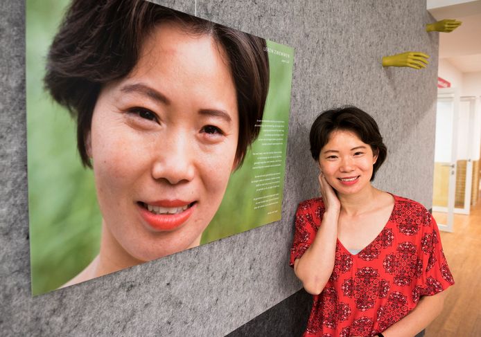 Lili Chang bij haar levensgrote portret in de bibliotheek aan de Neude, waar een foto-expositie is ingericht, gewijd aan Utrechters met een migratieachtergrond.