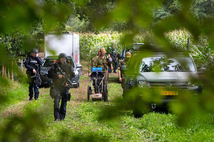 Zwaarbewapende agenten begeleidden de onderzoekers in het Zwolse bosje waar de wapens werden gevonden.