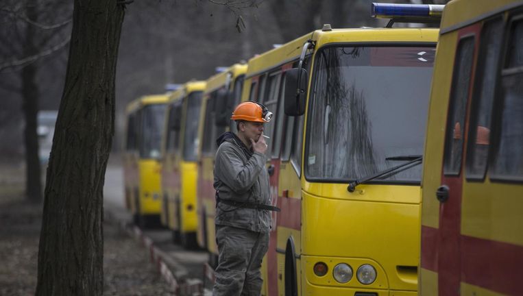 Een mijnwerker staat bij Oekraïense ambulances in de buurt van de mijn waar de ontploffing plaatsvond. Beeld reuters