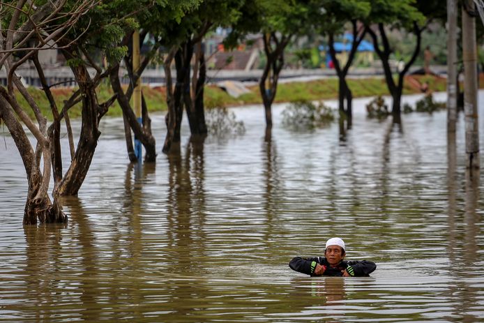 Een man waadde gisteren door het wader in Tangerang, dichtbij Jakarta. In het gebied regent het al dagen, wat zorgt voor overstromingen.