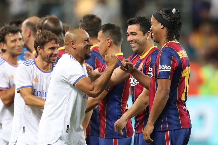 Brazilianen Roberto Carlos en Ronaldinho begroeten elkaar.