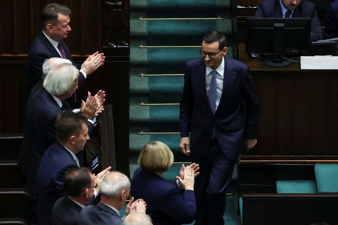 De Poolse premier Mateusz Morawiecki, van de conservatieve partij Recht en Rechtvaardigheid (PiS), wordt na zijn speech in het parlement toegejuicht door enkele leden van zijn partij.