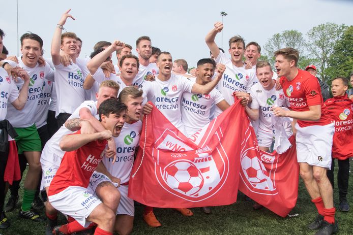 De selectie van Noordwijk viert het kampioenschap in de derde divisie. Vooraan, in het rode shirt, Gouwenaar Thomas Reynaers.