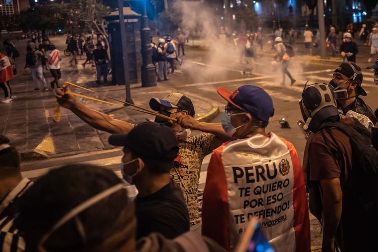 Aan het einde van de mars naar het parlementsgebouw in Lima komt het zaterdagavond tot een confrontatie tussen betogers en de politie.  Beeld Nicola Zolin voor de Volkskrant