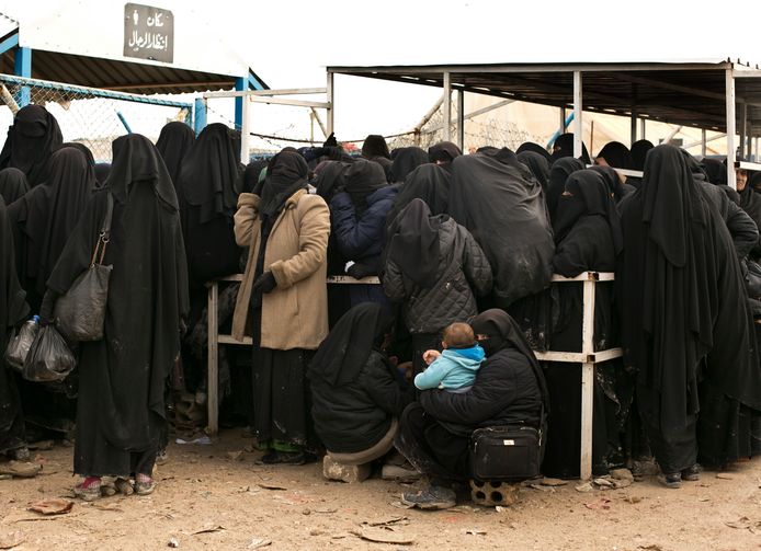 Vrouwen schuiven aan bij een bedeling van hulpmiddelen in het Al-Hol-vluchtelingenkamp in Syrië.