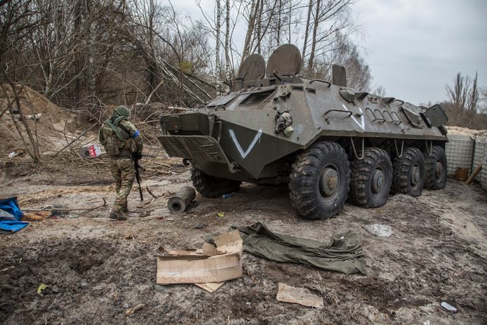 Seorang tentara Ukraina memeriksa kendaraan militer Rusia yang ditinggalkan di Chernobyl.