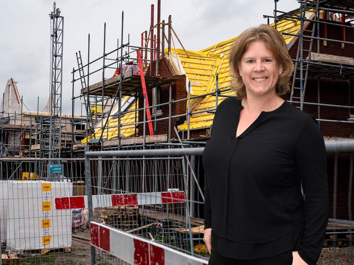 Columnist Daniëlle Pels, met op de achtergrond een huis dat wordt gebouwd.