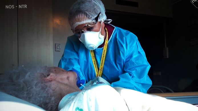 Verpleegkundige Sanna Elkadiri verpleegt een van de bewoners die besmet is met corona.