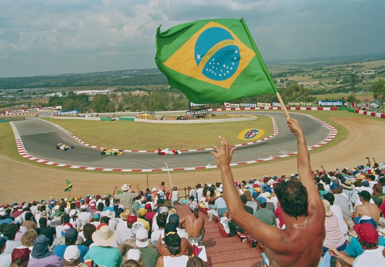 Een fan van de legendarische Braziliaanse F1-coureur Ayrton Senna zwaait met 1de vlag van het Zuid-Amerikaanse land tijdens de laatste GP van Zuid-Afrika op 4 maart 1993 die werd verreden op het circuit van Kyalami. Beeld Pascal Rondeau/Getty Images
