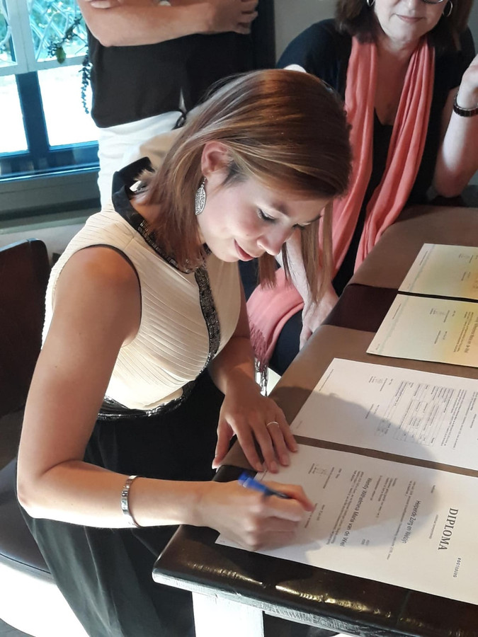 Wendy van de Wiel zet haar handtekening onder haar mbo-diploma.