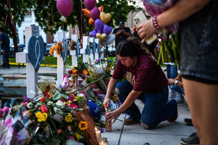 Iemand steekt een kaars aan bij bloemen ter nagedachtenis van de 21 slachtoffers van de schietpartij in Uvalde, Texas.