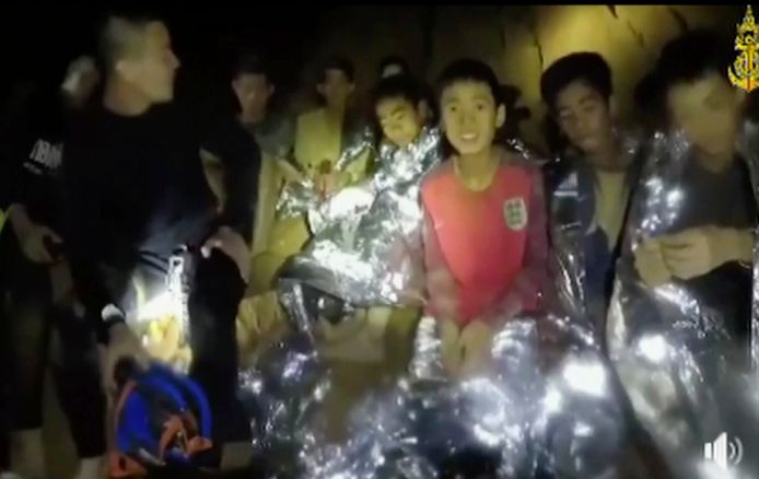 De twaalf Thaise kinderen en hun begeleider, opgesloten in de onder water gelopen grot Mae Sai in noord-Thailand, geven op videobeelden een teken van leven.