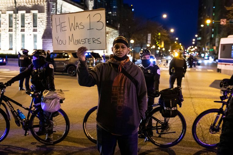 Een man houdt een protestbord omhoog tijdens een mars voor de doodgeschoten tiener Adam Toledo in Chicago. Beeld AP