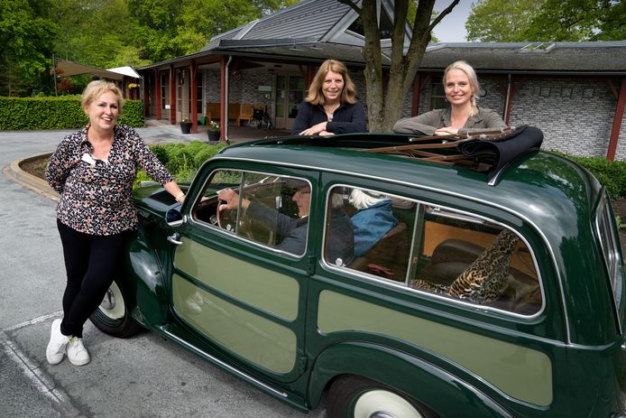 Hospice Duinsche Hoeve in Rosmalen bestaat 10 jaar. Van links naar rechts Dorien Aarts, Carla Talens en Anita Timmermans. In de auto een van de patiënten die wordt verwend met een ritje in de oldtimer.