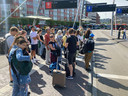 Reizigers wachten in Leiden op de bus naar Schiphol.