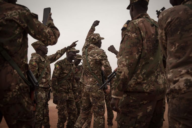 Malinese soldaten dansen na de ceremoniële overdracht van een militaire basis in Timboektoe. Beeld AFP