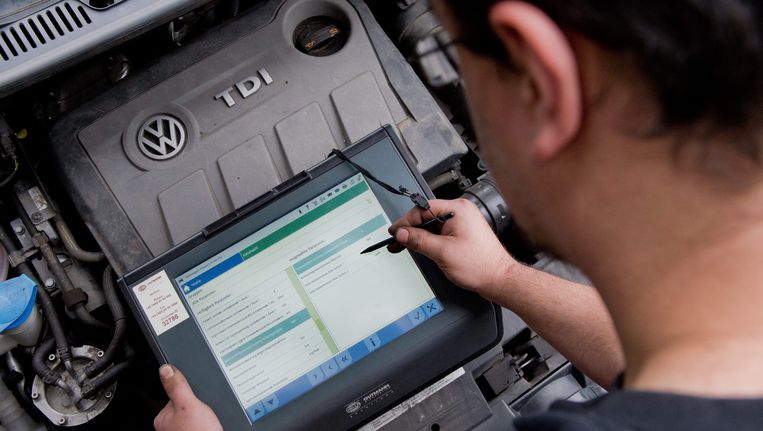 Een automonteur leest de gegevens van de TDI-dieselmotor van Volkswagen. Beeld epa