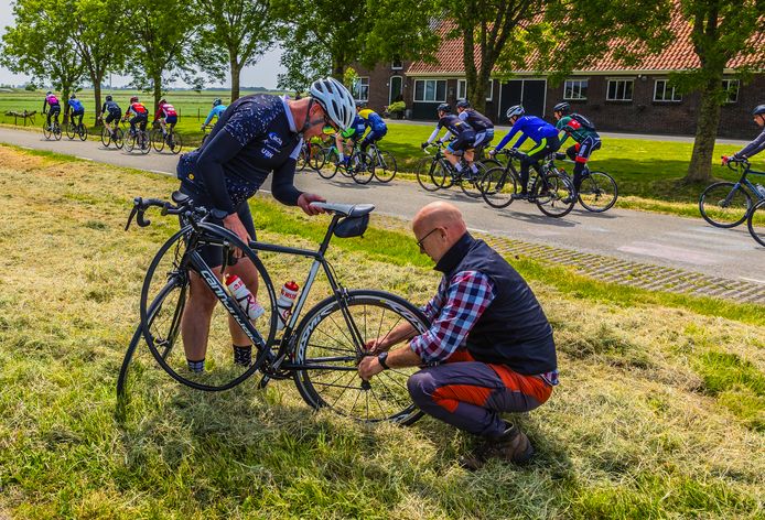 Mobiele fietsenmaker Jan de Roos helpt fietser Erwin Keizer met zijn fietsklapband.