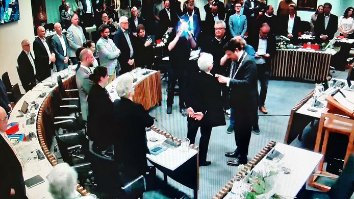 Burgemeester Han van Midden speldt Yvonne de Beer (RL) een koninklijke onderscheiding op in de raadszaal van Roosendaal.