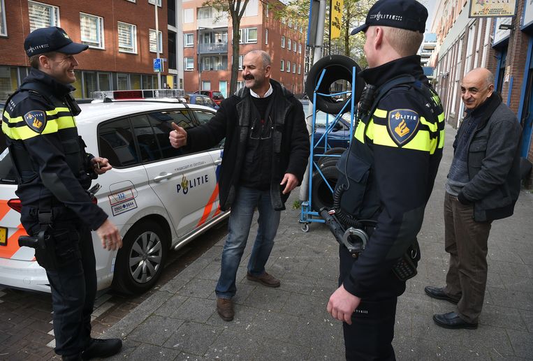 Wijkagenten in het Oude Westen in Rotterdam hebben plezier met een Turkse ondernemer. Beeld Marcel van den Bergh / de Volkskrant