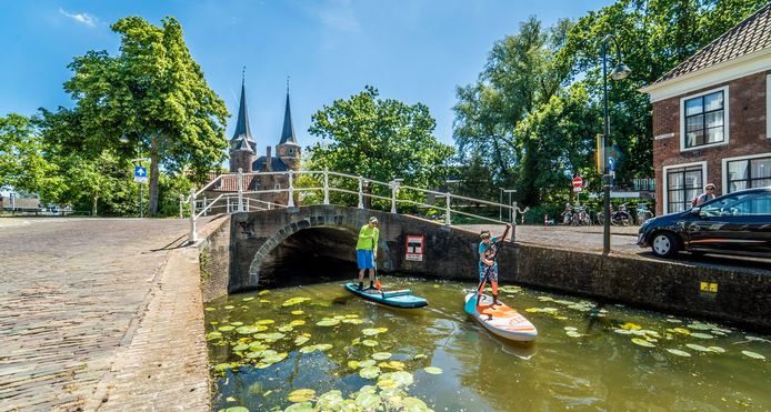 Arie en Wout van der Stap peddelen over het water langs de Oostpoort.