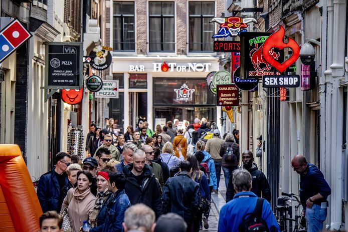 Voorbijgangers op de Wallen in de binnenstad van Amsterdam.