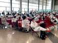 Honderden Chinese passagiers wachten in hazmat-pak op vlucht