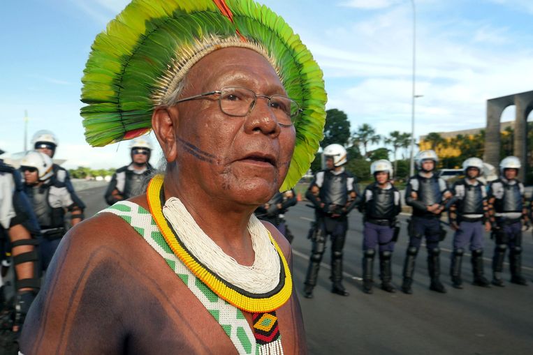 Paulinho Paiakan voor de oproerpolitie tijdens Free Land Camp, een protest van de APIB, de vereniging van Braziliaanse inheemse volken, in Brasilia 2017. Beeld AFP