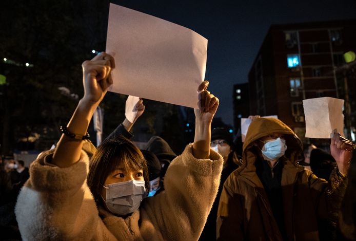 Demonstranten in Peking houden blanco vellen omhoog als symbool voor de censuur in China.