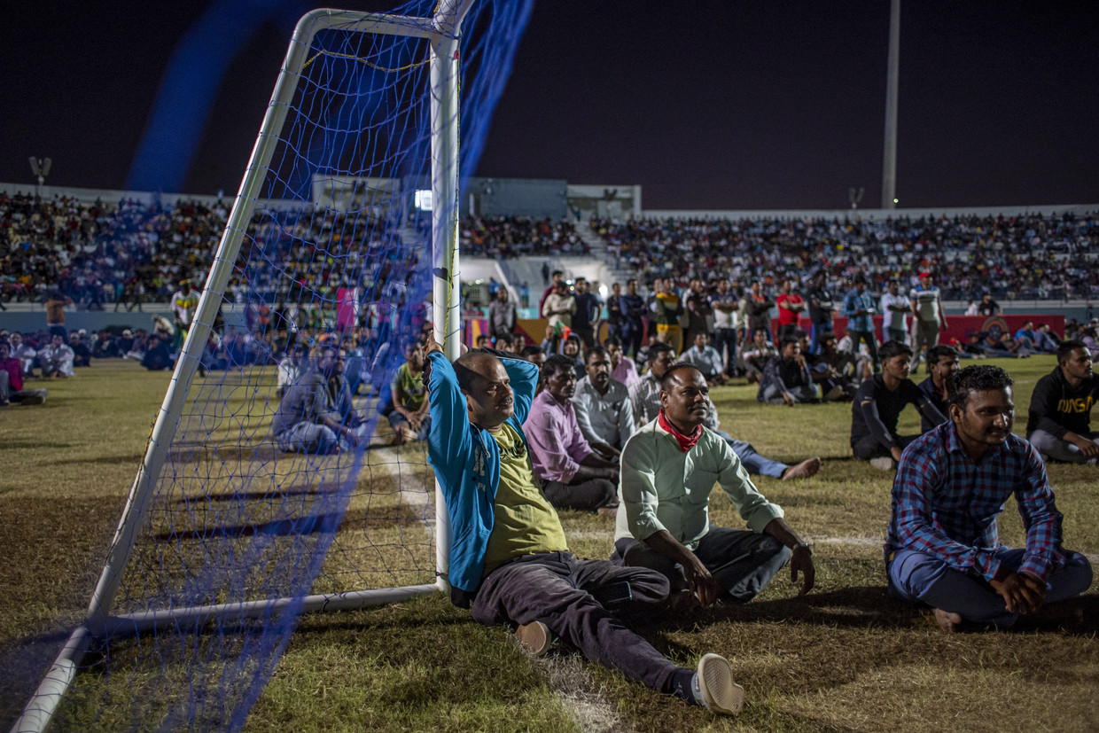 Voetbalfans kijken een WK-wedstrijd op schermen in het gratis toegankelijke cricketstadion in de migrantenwijk Asian Town, in Doha. 