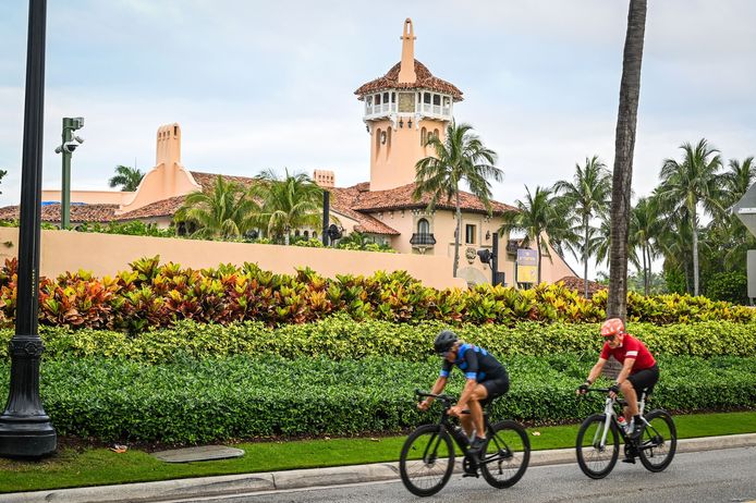 Twee mannen fietsen langs Trumps villa in Mar-a-Lago, Florida.
