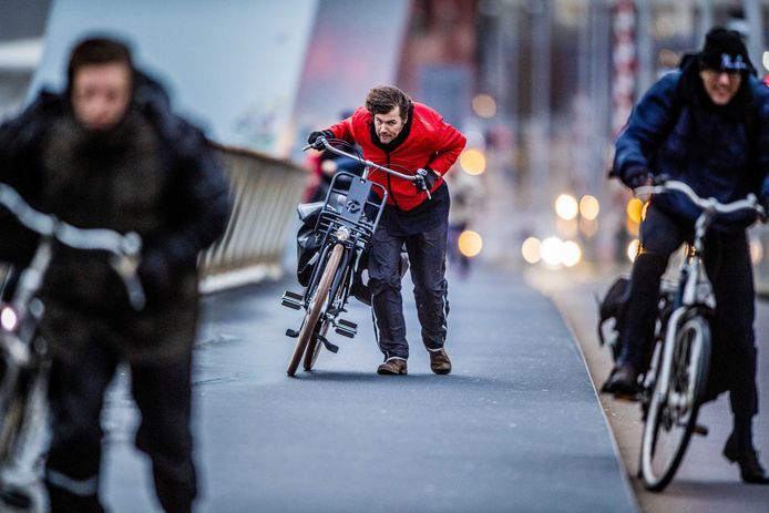 Een fietser trapt tegen de westerstorm op de Erasmusbrug in Rotterdam.