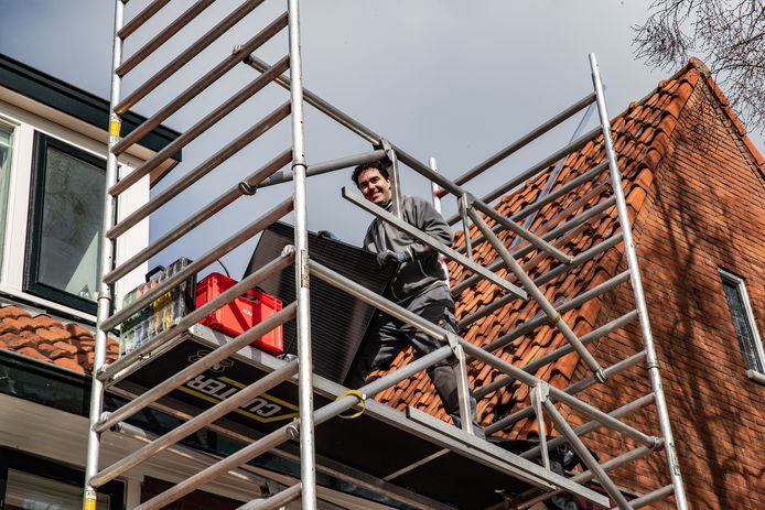 Boudewijn Meyboom monteert zonnepanelen op het dak van een woning in Deventer.